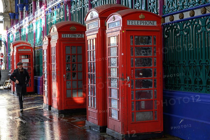 London, UK. January 30th 2025. A man walks past a row of old fashioned telephone boxes in Smithfield Market, the largest wholesale meat market in the UK