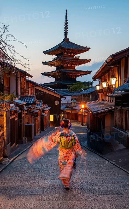 Japanese woman wearing kimono in an alley, Yasaka dori historic alleyway in the old town with traditional Japanese houses, five-story Yasaka pagoda of the Buddhist Hokanji Temple in the back, Higashiyama, Kyoto, Japan
