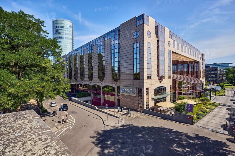 Hyatt Regency, hotel, commercial building, modern architecture, general development, parking strip with cars, flower bed, lawn, trees, elevated perspective, blue sky, cirrus clouds, cirrostratus clouds, Kennedy shore, Cologne, district-free city, North Rhine-Westphalia, Germany