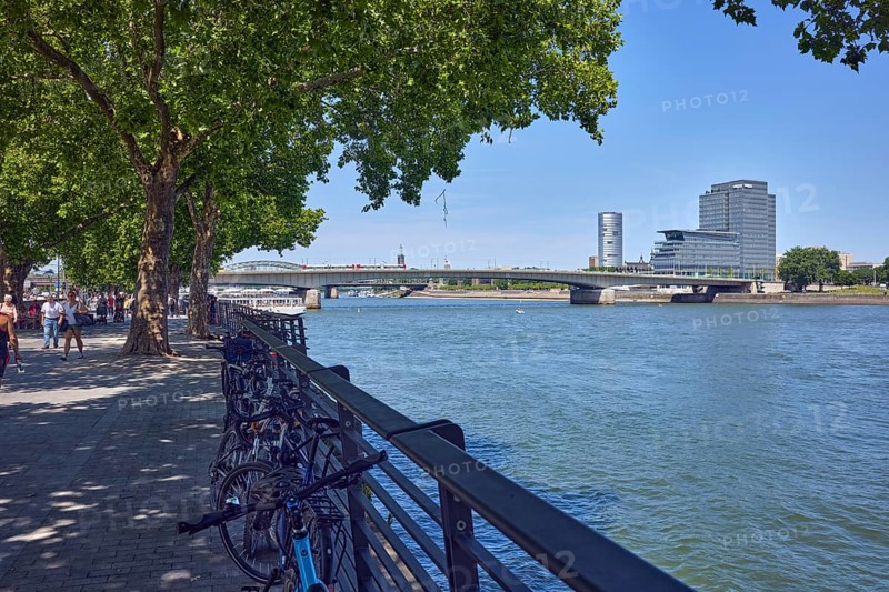 Rhine river, general architecture, MaxCologne high-rise building, bridge, Deutz bridge, metal railings, waterfront, trees, bicycles, pedestrians as accessories, image processing contrasts, blue sky, cloudless, Leystapelwerft, Cologne, district-free city, North Rhine-Westphalia, Germany