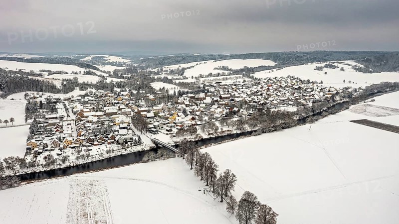 Snowy village with river and hills in the background, quiet winter atmosphere, Lauchröden in Thuringia