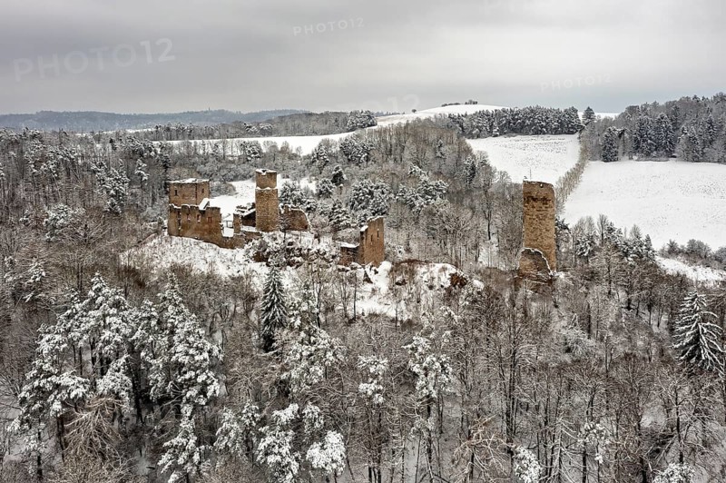 Snowy castle ruins in a wooded winter landscape, surrounded by rolling hills, The Brandenburg in the Werra Valley near Eisenach
