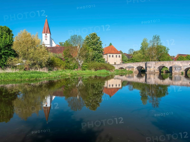 The small village of Ebermergen with church tower and stone bridge, medieval stone bridge over the Wörnitz river with reflection, Harburg, Swabia, Bavaria, Germany