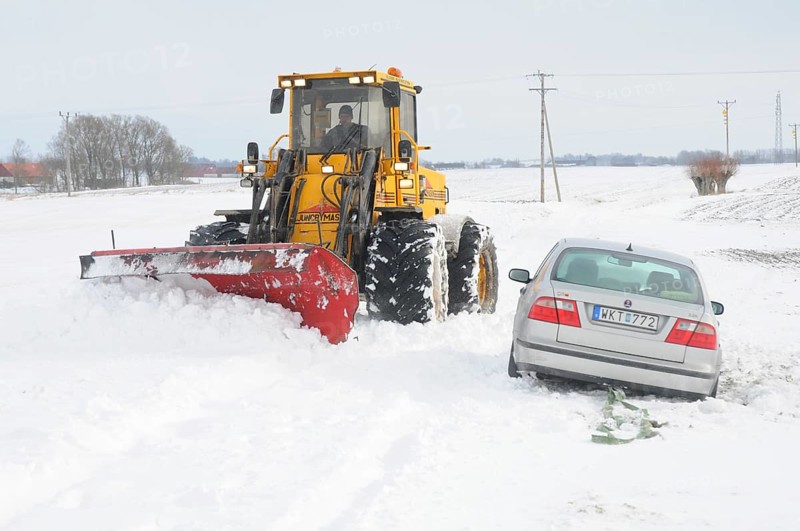 Car stuck in snow gets help from a loader to get free in Skurup municipality, Skåne county, Sweden, Scandinavia