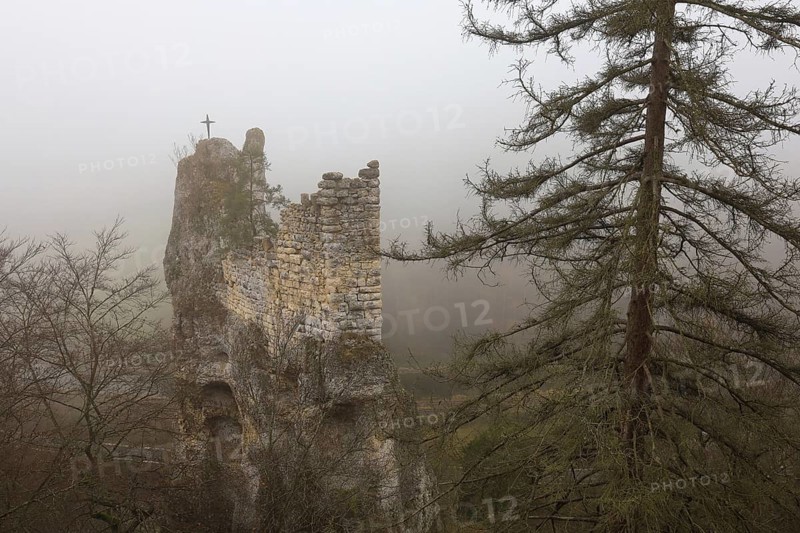 An abandoned castle ruin in fog with a cross on the tower, surrounded by trees and an autumnal atmosphere, Gruene Gutenstein ruins, Obere Donau nature park Park, Inzigkofen, Dietfurt, Sigmaringen district, Baden-Württemberg, Germany
