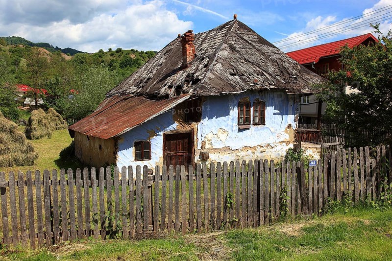 Traditional Romanian farmhouse that is in a dilapidated or abandoned state. The eye-catching light blue color of the outer walls is common in many Romanian villages, such houses are characteristic of rural regions in Romania, particularly Transylvania, Transylvania