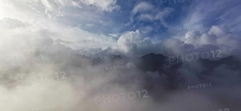 Atmospheric scene with clouds and fog over a mountain landscape under blue sky, hiking in the High Tatras National Park, Carpathian Mountains, Poland