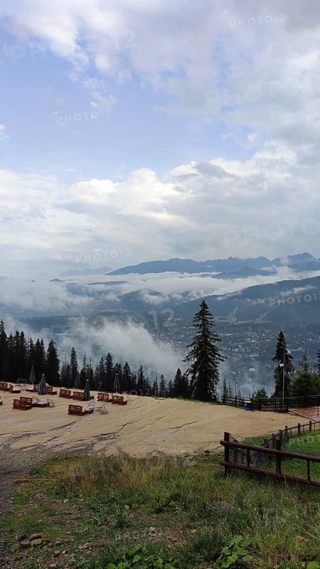 Panoramic view from a viewpoint on Mount Gubalowka with clouds, mountains and a town in the valley, Zakopane, hiking in the High Tatras National Park, Carpathian Mountains, Poland