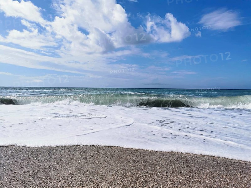 Roaring ocean waves on the beach under a clear blue sky, Dhermi, Albanian Riviera, Albania