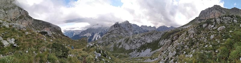 Wide mountain panorama under cloudy sky, with rocky elevations and a valley, Peaks of the Balkans, hiking in the Albanian Alps National Park, Albania, Peaks of the Balkans, hiking in the Albanian Alps National Park, Albania