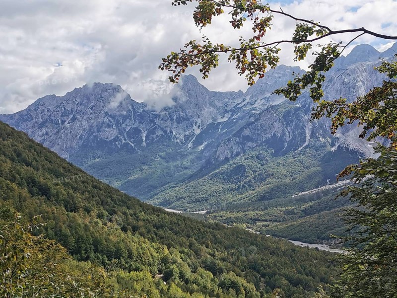 Panorama of a mountain range with forests and few clouds in the sky, Peaks of the Balkans, hiking in the Albanian Alps National Park, Albania