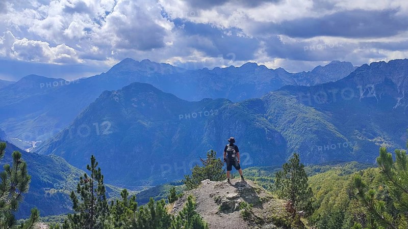 Hikers on peaks with views of mountain scenery and dramatic skies, Peaks of the Balkans, hiking in the Albanian Alps National Park, Albania