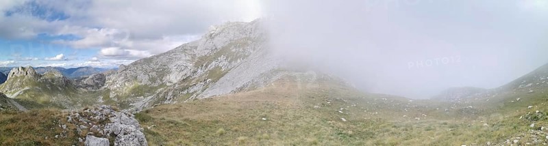Mountain landscape with fog that partially obscures the view, under a changing sky, Peaks of the Balkans, hiking in the Albanian Alps National Park, Albania