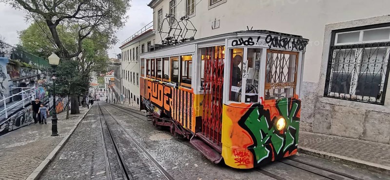 Historic funicular, Elevador da Gloria with graffiti goes down a steep road, Lisbon, Portugal