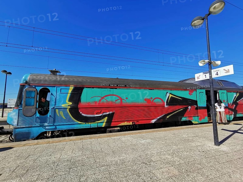 A train painted with graffiti stands on a sunny platform, Lagos, Algarve, Portugal