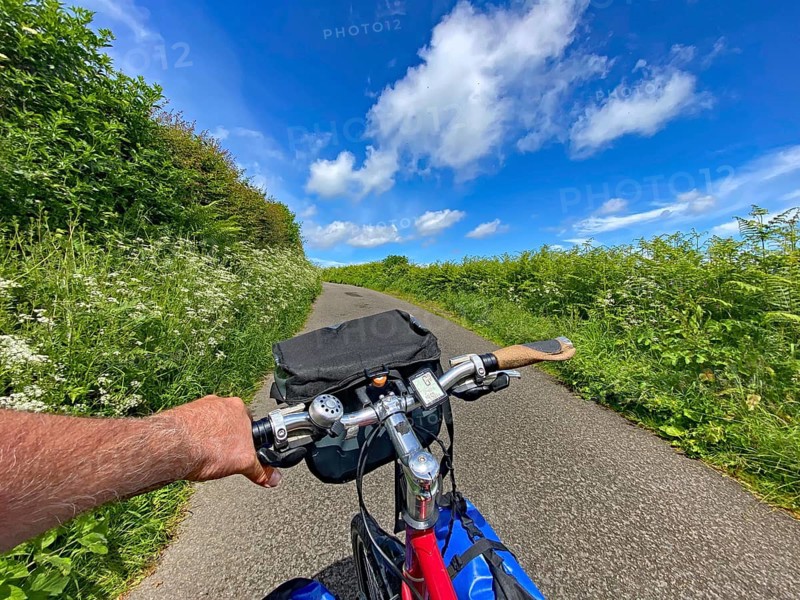 View of a bike ride along a green path under clear blue sky, Highlands, Scotland, Great Britain