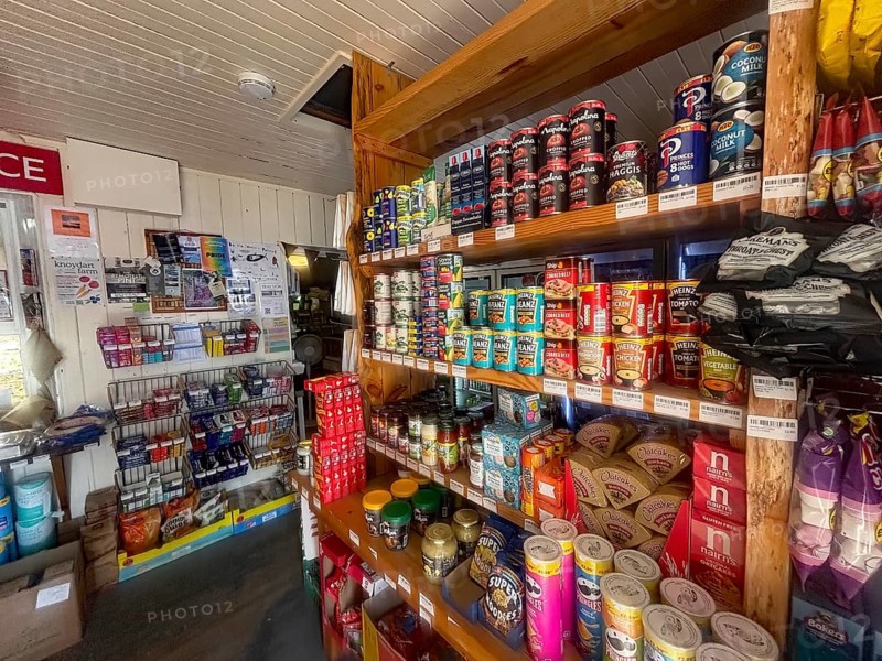 A small shop with stocked shelves full of cans and colorful food products, the only shop in the remote village of Knoydart, Scotland, Great Britain
