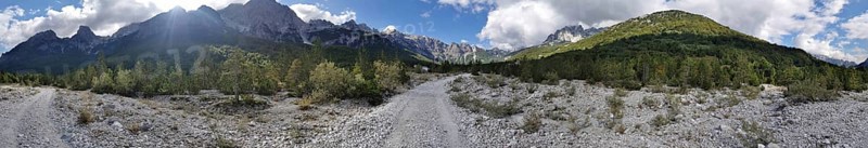 Panorama, dirt road through a wooded mountain landscape under a cloudy sky, Albanian Alps National Park