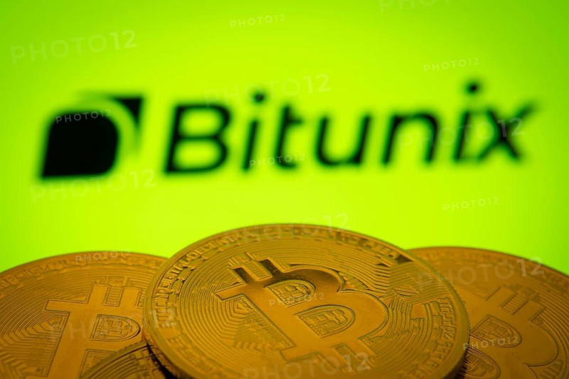 Dhaka, Bangladesh- 03 Sep 2025: Close-up of Bitcoin coins with the Bitunix logo visible on a screen in the background
