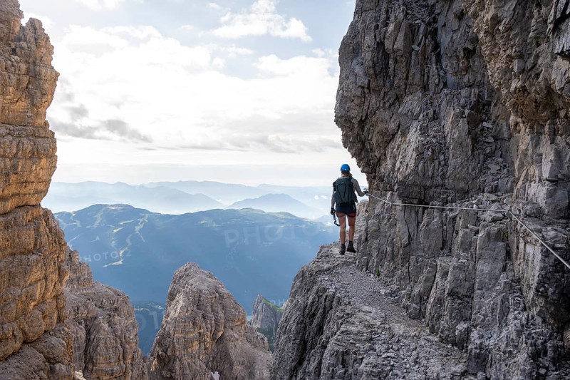 Climbers on a rock band, Bocchette Centrale band trail, via ferrata in the Brenta Mountains, Brenta-Adamello Natural Park, Trentino, Italy