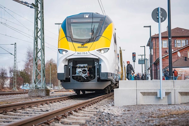 Modern locomotive on railroad tracks in front of buildings and power lines, opening of the Hermann Hesse Railway, Calw, Germany