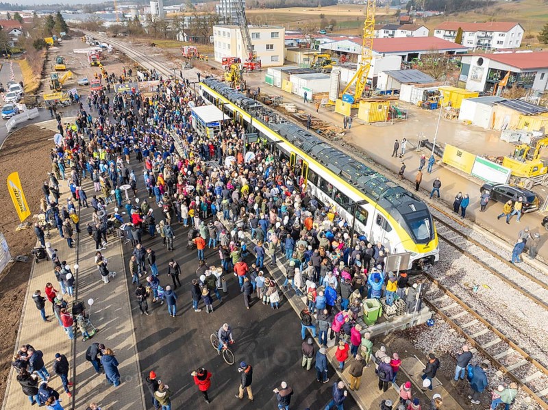 Large crowd at an event with train and cranes on a construction site, opening of the Hermann Hesse Railway, Calw, Germany