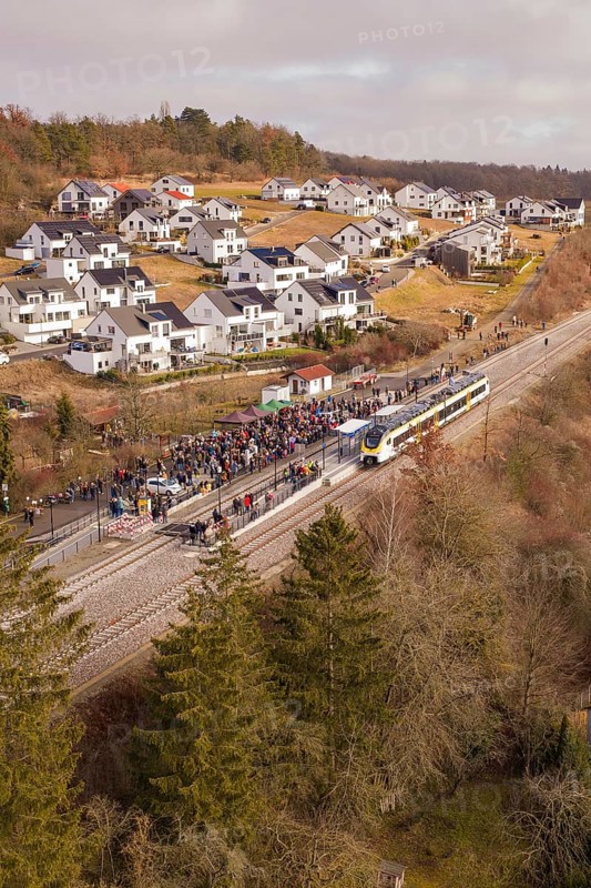 A train crosses a small village surrounded by forest and winter atmosphere, opening of the Hermann Hesse Railway, Calw, Germany
