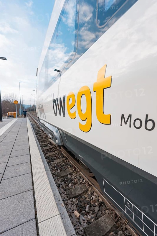 A white train on the tracks with visible lettering under a blue sky, opening of the Hermann Hesse Railway, Calw, Germany