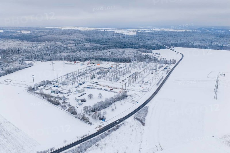 Snowy substation and road in the midst of a winter landscape with thick forests, substation, Jettingen, Germany