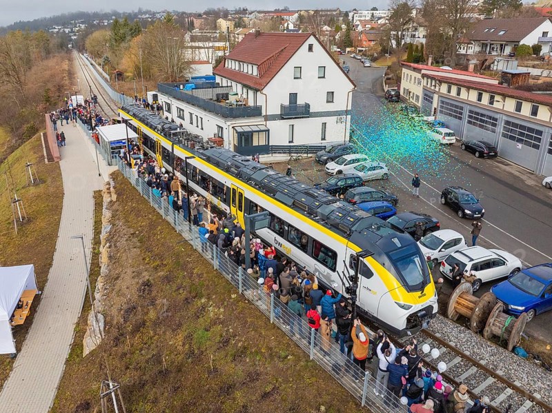 Zug at an event with people and rain of confetti, surrounded by vehicles and buildings, opening of the Hermann Hesse Railway, Calw, Germany