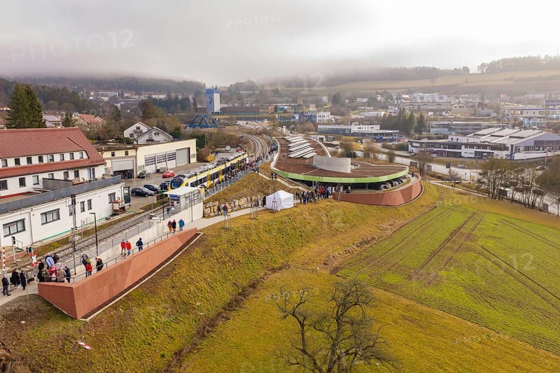 Station from above with surrounding urban landscape and people, drafty morning sky, opening of the Hermann Hesse Railway, Calw, Germany
