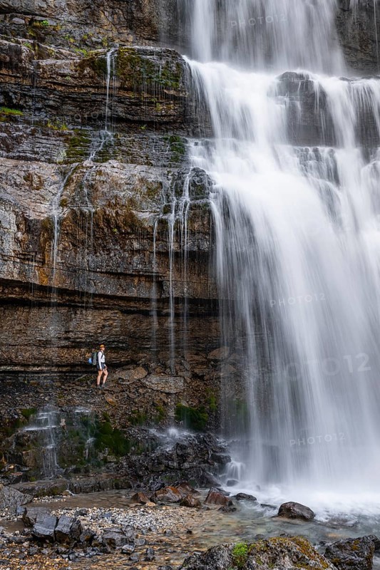 Little hiker in front of large Cascata di Mezzo waterfall, long exposure, Vallesinella, Brenta, Trentino, Italy
