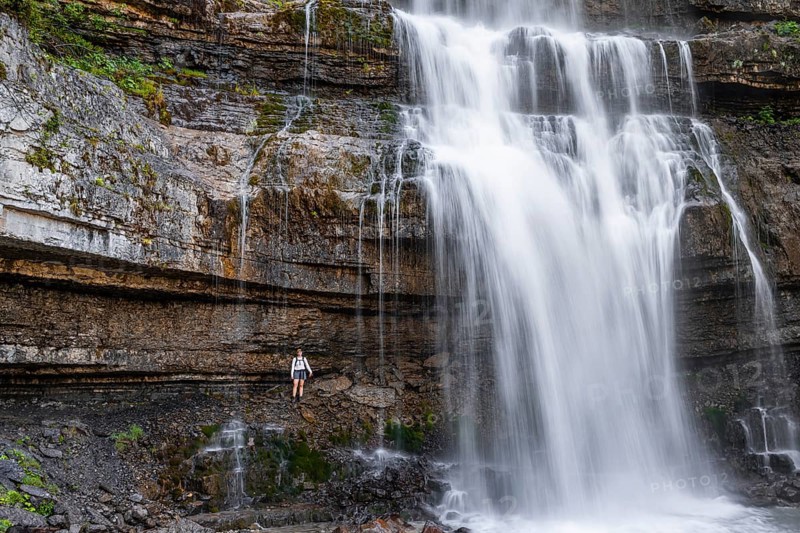Little hiker in front of large Cascata di Mezzo waterfall, long exposure, Vallesinella, Brenta, Trentino, Italy