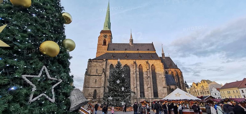Christmas market in front of a big church with festive decoration and people, Pilsen, Czech Republic