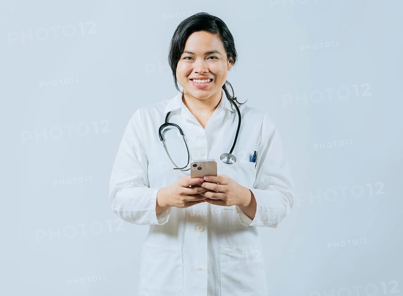 Young asian female doctor holding phone looking at camera isolated, Concept of online medical services