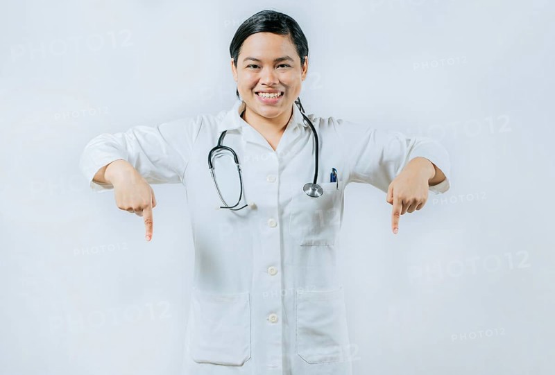 Young asian female doctor recommending an advertisement. Asian female doctor pointing at medical banner isolated