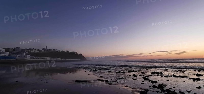 Sunset over a quiet beach, shimmering waves in evening light, Morocco
