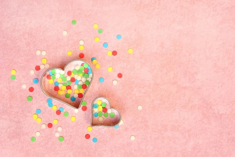 Two heart-shaped baking pans and sugar confetti
