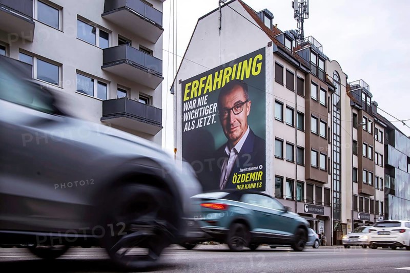 Mega poster on a house pediment. Cem Özdemir, leading candidate of the Green Party. 2026 state election in Baden-Württemberg. Election advertising in the city center of Stuttgart. Stuttgart, Baden-Württemberg, Germany
