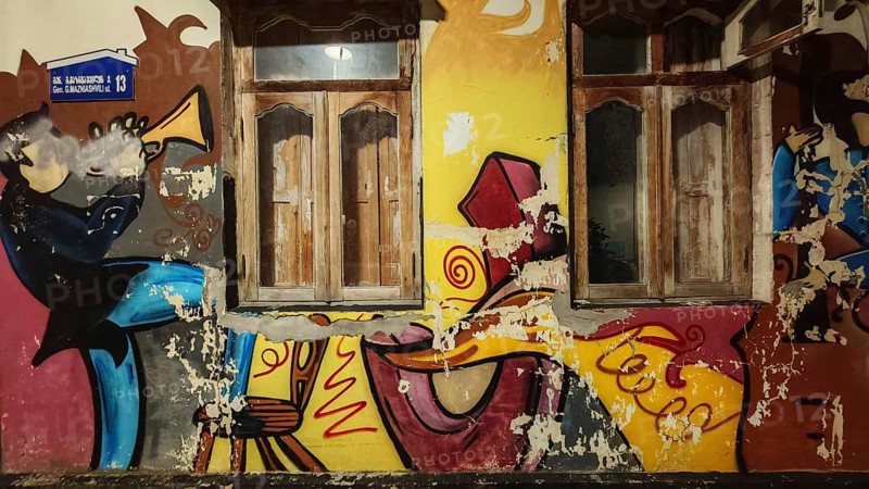 Colour-intensive graffiti with two windows, creative and dynamic wall design