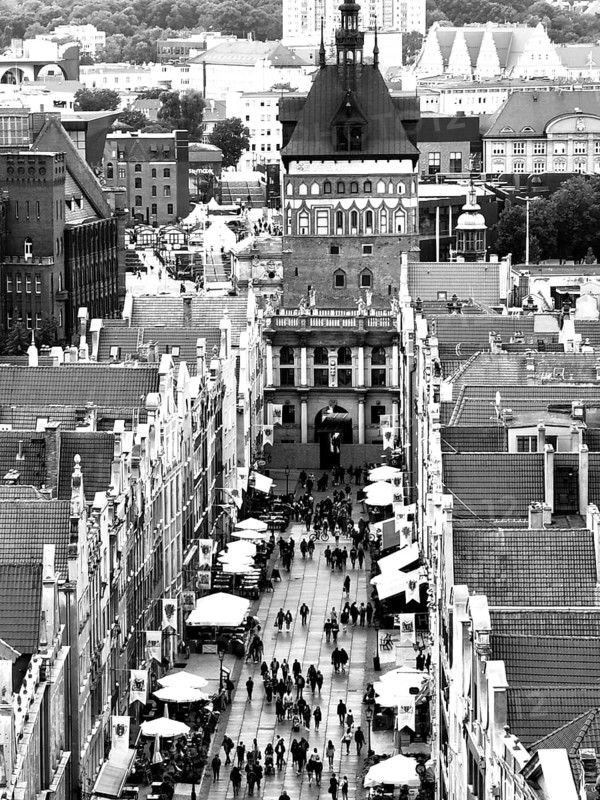 View of a busy street with a dominant tower in the background, Gdansk, Poland