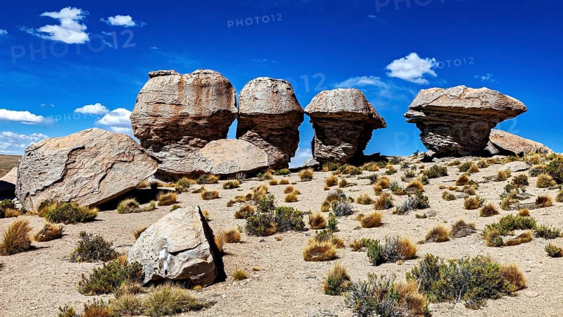 Remarkable rock formations rise in a dry desert landscape under clear skies, The landscape of the Altiplano in Bolivia