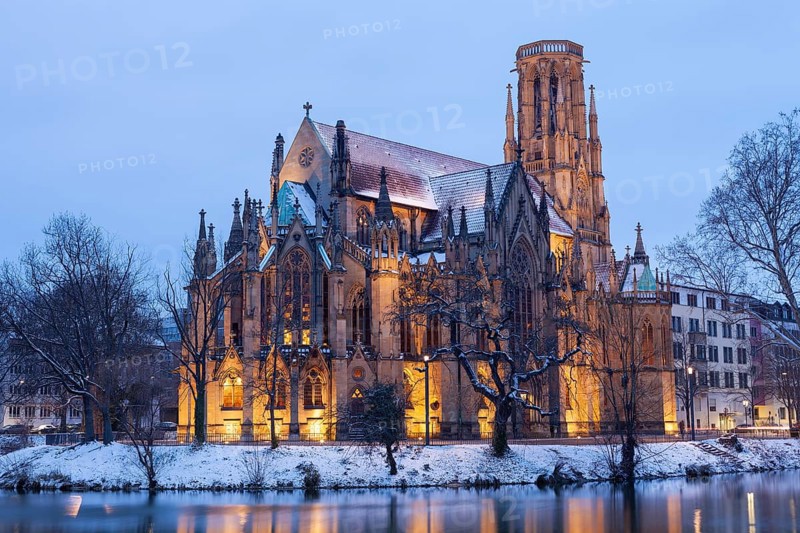 March 18, 2018, winter dusk with snow, illuminated lake and Gothic church Johanneskirche, calm reflections, Feuersee, Stuttgart, Baden-Württemberg, Germany