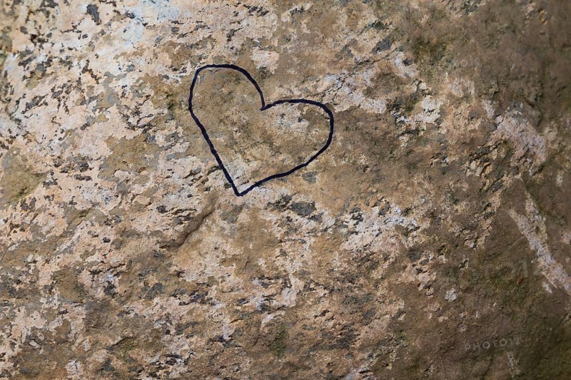Close-up of painted black heart outline symbol on tanned nuanced rock surface, Quebec, Canada