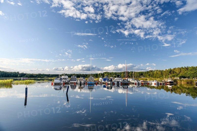 Several boats are moored in the quiet pleasure boat harbor of Ekenäs, water reflects the sky, Ekenäs, Värmlandsnäs peninsula, Värmlands län, Sweden