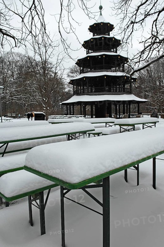 Winter in the English Garden, snow-covered beer garden tables and benches, Chinese Tower, Munich, Bavaria, Germany