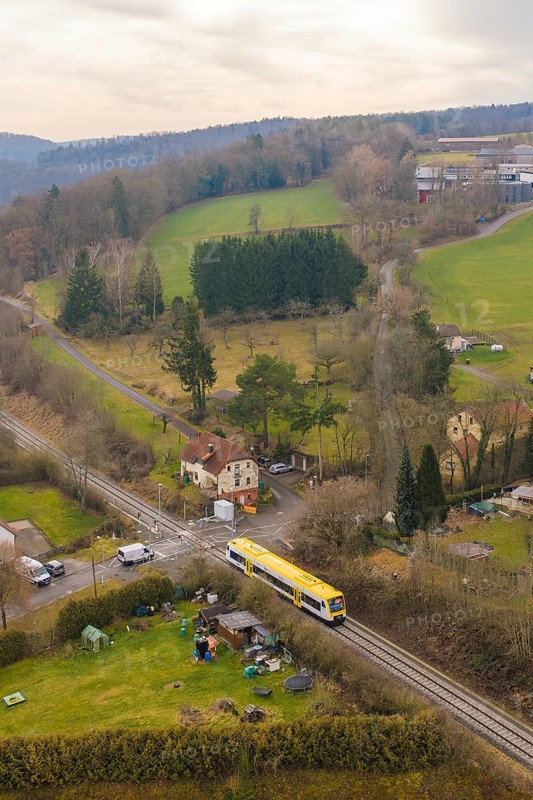 Rural scene with yellow train in green countryside and scattered houses, acceptance of the Hermann Hesse Railway, Calw, Black Forest, Germany
