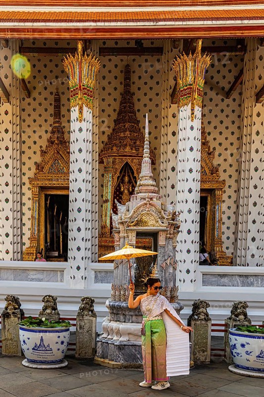 Young woman wearing a parasol in traditional clothing presents herself for the photographers, Wat Arun Buddhist temple, Bangkok, Thailand's metropolis, Thailand