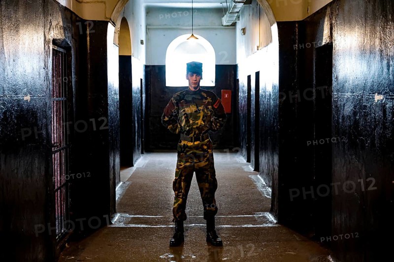 A guide in uniform stands in the corridor of the Karosta prison in Liepaja, Liepaja, Courland, Latvia