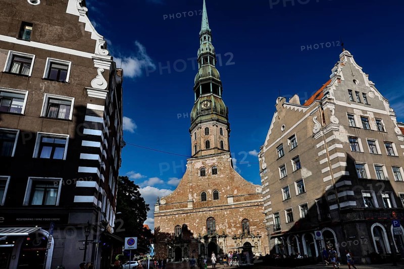 Gothic St. Peter's Church in Riga between historic buildings in sunlight, Riga, Latvia